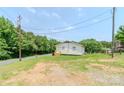Side view of home, surrounded by green grass, trees and a paved street at 462 Berry Hill Dr, Norwood, NC 28128