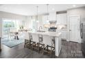 A stylish kitchen with white cabinets, granite countertops, stainless steel appliances, and an island with bar seating at 518 Durango Way, Denver, NC 28037