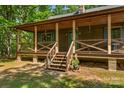 Inviting covered front porch with wooden railings, stairs, and space for seating to enjoy the view at 536 Brookhaven Rd, Statesville, NC 28625