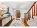 Bright and inviting foyer with hardwood floors, elegant staircase, and natural light at 7103 Forest Ridge Rd, Matthews, NC 28104