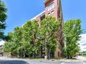 Modern brick condo building surrounded by lush trees and clear blue skies at 715 N Church St # 213, Charlotte, NC 28202