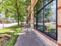 A sidewalk view of a condo building showing windows, greenery, and the street at 715 N Church St # 213, Charlotte, NC 28202