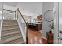 View of the stairway leading to the kitchen with an island and barstool seating at 7341 Adare Mews Rd, Charlotte, NC 28217