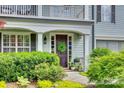 Close-up of a beautiful front door with sidelights, a wreath, and lush landscaping at 1020 Forbishire Dr, Matthews, NC 28104