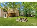 A well-maintained backyard features an outdoor sitting area with mature trees for privacy and a wooden deck at 104 Whiterock Dr, Mount Holly, NC 28120