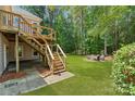 Beautiful backyard featuring a staircase to a deck with an outdoor sitting area around a fire pit at 104 Whiterock Dr, Mount Holly, NC 28120