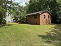 Spacious backyard featuring a well-maintained lawn surrounding a charming brick home at 13134 Homewood Dr, Charlotte, NC 28262