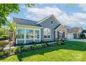 Attractive gray home with a well-manicured lawn and flowering plants, creating inviting curb appeal at 1328 Somersby Cir, Gastonia, NC 28054