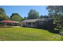 This brick home features a welcoming front porch and convenient carport, all set on a green lawn at 133 Pine State Rd, Troutman, NC 28166