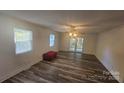 Spacious living room with wood-look floors, ceiling fan, and natural light from multiple windows at 133 Pine State Rd, Troutman, NC 28166