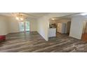 Open-concept living area with wood-look floors connecting to the kitchen with lots of natural light at 133 Pine State Rd, Troutman, NC 28166