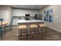 Modern kitchen with stainless steel appliances, white cabinets, an island with seating, and stylish hardwood flooring at 1421 Wildflower St, Newton, NC 28658