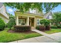 Charming home featuring a quaint front porch, colorful landscaping, and a neatly maintained lawn at 15714 Laurel Oak Cres, Davidson, NC 28036