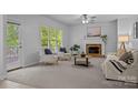 Bright living room with plush carpeting, fireplace, and ample natural light from large windows at 15831 Breton Brook St, Huntersville, NC 28078