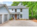 Two-story home featuring a quaint front porch, gray siding, and an attached two-car garage, enhancing curb appeal at 18028 Broken Woods Rd, Charlotte, NC 28278