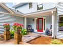 Charming front porch showcasing colorful flower pots and rocking chairs, adding a touch of Southern comfort to the entrance at 18028 Broken Woods Rd, Charlotte, NC 28278