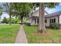 Traditional home with a sidewalk leading to a covered front porch, lush green lawn, and mature shade trees at 188 Turnberry Ln, Mooresville, NC 28117