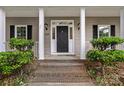 Charming home's front entrance featuring a black door, sidelights, and manicured landscaping at 188 Turnberry Ln, Mooresville, NC 28117