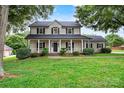 Charming two-story home with a welcoming front porch and well-manicured lawn and trimmed bushes at 188 Turnberry Ln, Mooresville, NC 28117