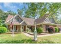 Inviting exterior of home showing brick facade, landscaped yard, and classic American flag at 2020 Olde Towne Dr, Monroe, NC 28110