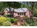 Attractive brick home featuring a covered front porch and well-maintained landscaping with mature trees at 2804 Pulaski Dr, Monroe, NC 28110