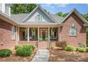 Inviting covered front porch with brick steps, black railings, and a charming front door with sidelights at 2804 Pulaski Dr, Monroe, NC 28110