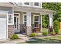 Inviting front porch featuring stone accents, rocking chairs, and manicured landscaping at 3615 Alamito Ln, Charlotte, NC 28214