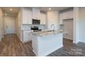 Spacious kitchen equipped with stainless steel appliances, white cabinets, and a large island with granite countertops at 4213 Summit Woods Dr, Charlotte, NC 28216