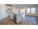 Bright kitchen featuring a granite island, stainless steel appliances, white cabinets, and wood-look flooring, perfect for entertaining at 4213 Summit Woods Dr, Charlotte, NC 28216