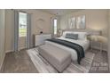 Bedroom features a large bed, neutral color palette, and a sitting bench for added comfort and style at 4217 Summit Woods Dr, Charlotte, NC 28216