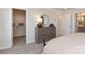 Bedroom with gray carpet, large dresser, and walk in closet at 4229 Summit Woods Dr, Charlotte, NC 28216