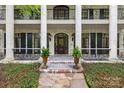 Covered porch with iron railing detail, columns, double doors, planters and stone floor at 4523 Fox Brook Ln, Charlotte, NC 28211