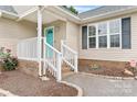 Close-up of the front porch with turquoise door, white railings, and landscaped walkway at 5052 Swinging Bridge Rd, Conover, NC 28613