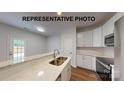 Modern kitchen with white cabinets, stainless steel appliances, marble countertops, and a breakfast bar with a sink at 601 Queens Rd, Gastonia, NC 28052