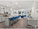 Modern kitchen open to the living room, featuring a large island with seating and stylish pendant lighting at 6381 Trinity Crossing Cir, Kannapolis, NC 28081