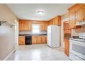Well-lit kitchen featuring wooden cabinets, white appliances, tile flooring, and a bright, airy feel at 6573 Weldon Nw Cir # 22, Concord, NC 28027