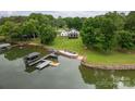 Aerial view showcasing the lakefront home, boat dock, and landscaped yard with a fire pit at 7455 Ivey Dr, Sherrills Ford, NC 28673
