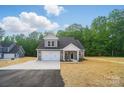 Inviting two-story home with a manicured lawn, attached garage, and classic gray and white color scheme at 908 Westminster Dr, Statesville, NC 28677