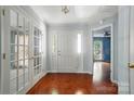 Bright foyer with hardwood floors, white trim, and double glass doors leading to another room at 9927 Raddington Ln, Charlotte, NC 28269