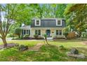 Inviting two-story home showcasing a lush front yard, mature trees, and a classic exterior at 1014 Vandalia Dr, Charlotte, NC 28212
