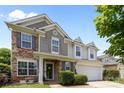 Charming two-story home featuring a two-car garage, stone accents, and manicured landscaping at 10418 Cullen Ct, Charlotte, NC 28278
