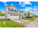 Two-story home with vinyl siding, blue shutters, two car garage, and manicured lawn at 115 Crownpiece St, Troutman, NC 28166