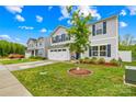 Well-maintained front yard with green grass, fresh mulch, and a young tree in a landscaped bed at 115 Crownpiece St, Troutman, NC 28166