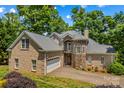 Beautiful stone and brick home featuring a well-manicured lawn and attached two car garage at 141 Ridge Top Rd, Mooresville, NC 28117
