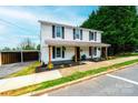 Two-story home featuring siding, a covered porch, and a parking area, set against a backdrop of trees and sky at 210 W 15Th St, Newton, NC 28658