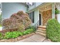 Inviting front porch with stone accents and manicured landscaping leading to the front door at 2100 Sablewood Dr, Charlotte, NC 28205