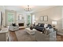 Elegant living room featuring a fireplace, large windows, and stylish furnishings at 2100 Sablewood Dr, Charlotte, NC 28205