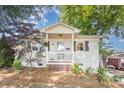Inviting front exterior featuring a quaint porch, stylish white brick, and meticulously maintained landscaping at 2109 Brewton Dr, Charlotte, NC 28206