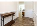 Hallway with wooden table, wainscoting, and wood-look flooring leading to living area at 2141 Bexar Trl, Matthews, NC 28105