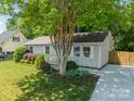 Lovely single-story home with lush landscaping, a mature tree, and a cozy front porch at 21614 Colina Dr, Cornelius, NC 28031